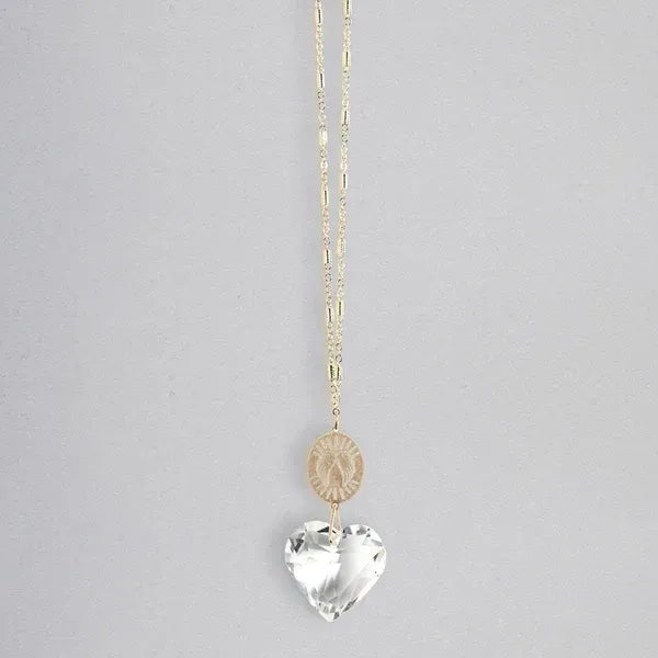 A delicate gold-toned pocket suncatcher necklace with a rose-gold coin charm and faceted clear crystal heart pendant for women’s boho chic clothing from shop daisy