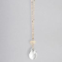 A pocket suncatcher featuring a gold-toned chain and clear faceted teardrop crystal pendant with heart-shaped bail