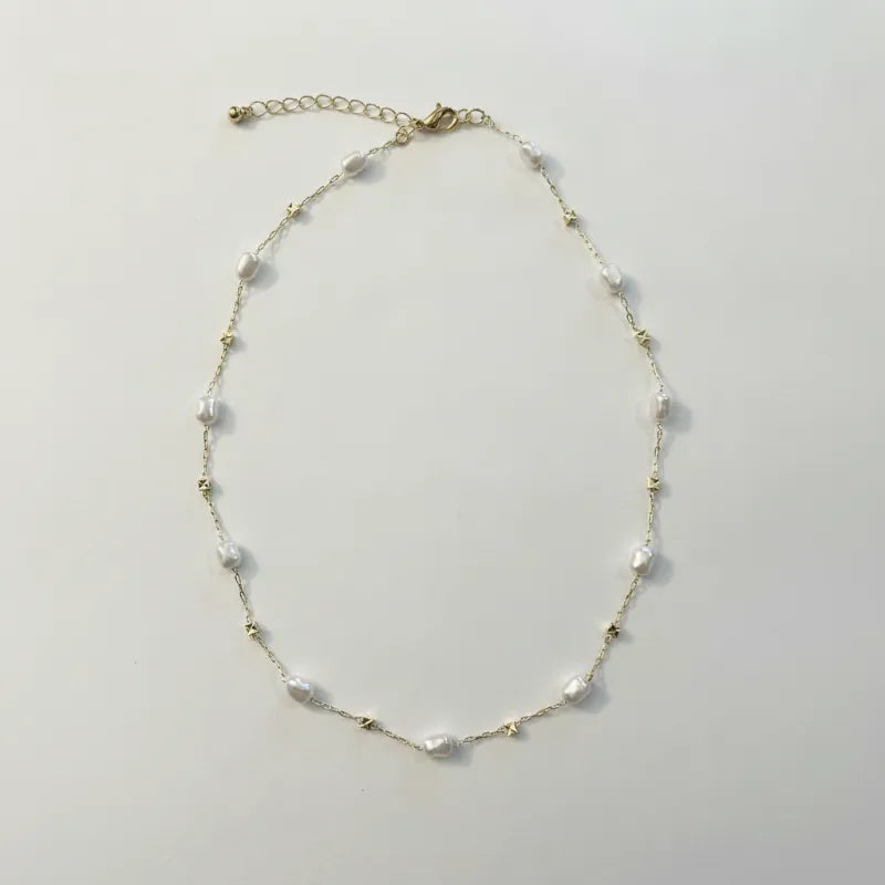 Delicate white pearl gold cube necklace with gold-toned chain and star-shaped metallic accents in irregular shapes