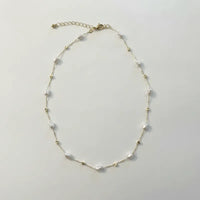 Delicate white pearl gold cube necklace with gold-toned chain and star-shaped metallic accents in irregular shapes