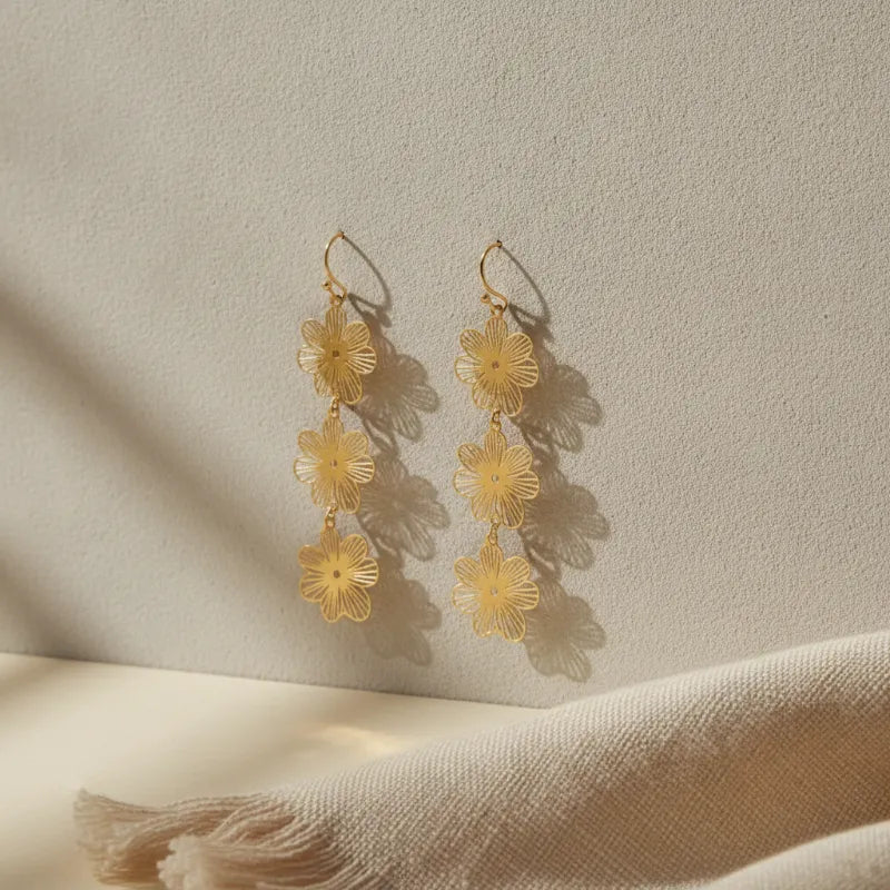 Delicate gold-toned three-tiered gold blossom statement dangle earrings with layered flower motifs