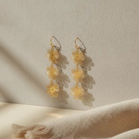 Delicate gold-toned three-tiered gold blossom statement dangle earrings with layered flower motifs