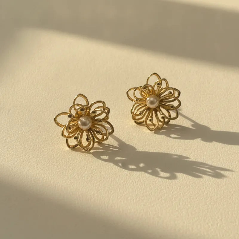 Elegant gold wire filigree blossom stud earrings featuring delicate flower shapes with intricate wirework and pearl centers