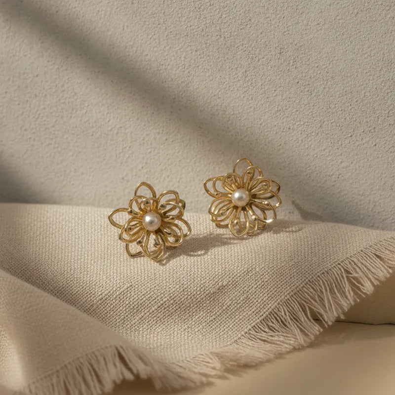 Elegant gold wire filigree blossom earrings featuring delicate flower design with intricate wirework and central pearl