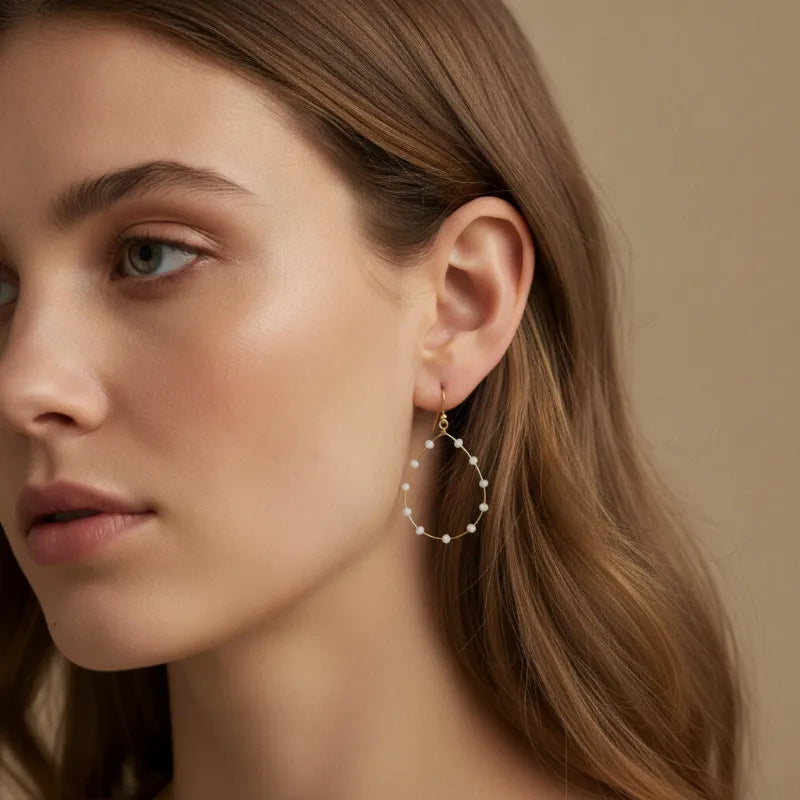 Dainty gold wire beaded teardrop earrings featuring delicate gold-toned hoops with small white pearls