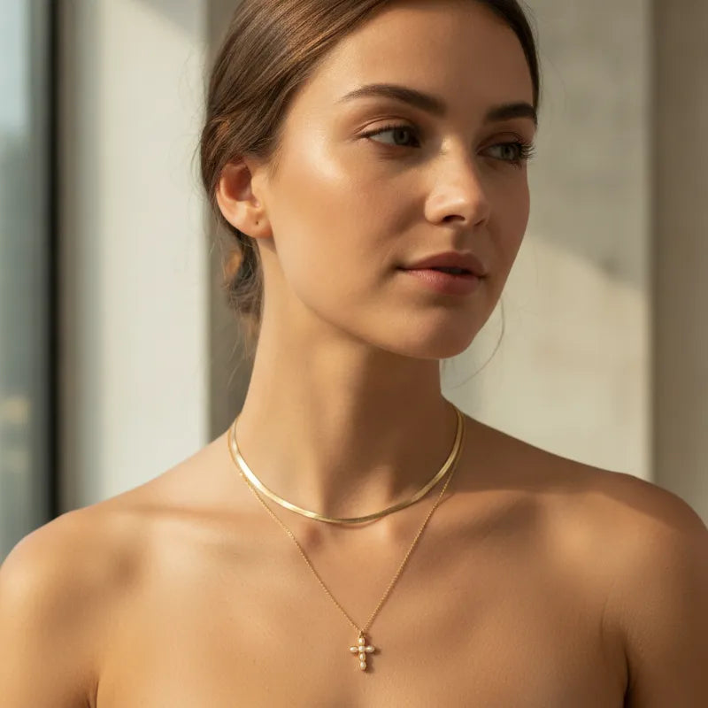 Delicate gold-toned double snake chain necklace with slender choker and small cross pendant with gemstone accents