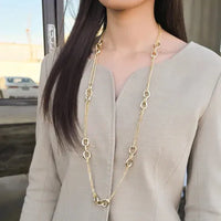 Delicate gold-toned mixed link chain necklace with fine chain and larger oval link charms for elegant wear