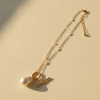 Gold plated beaded chain necklace with pearl pendant featuring an irregular white pearl and toggle clasp accents