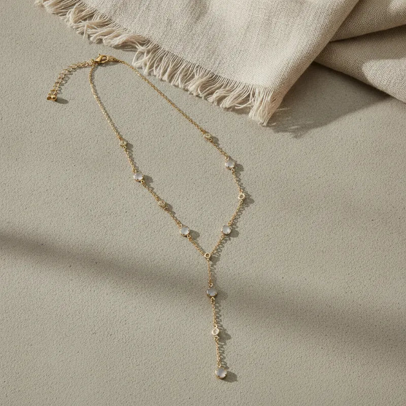 A delicate classic gold lariat drop necklace with pale moonstone beads along its gold chain