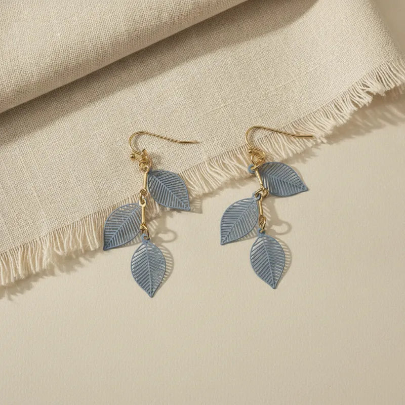 Delicate light blue leaf shaped dangle earrings with gold filigree triple leaf design and gold toned hooks