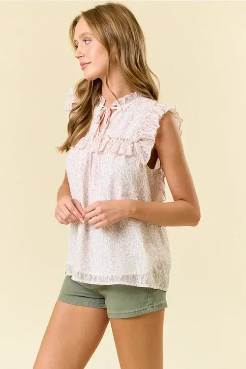 A light pink lace ditsy floral split v neck flowy blouse with ruffled sleeves and a tie-front neckline