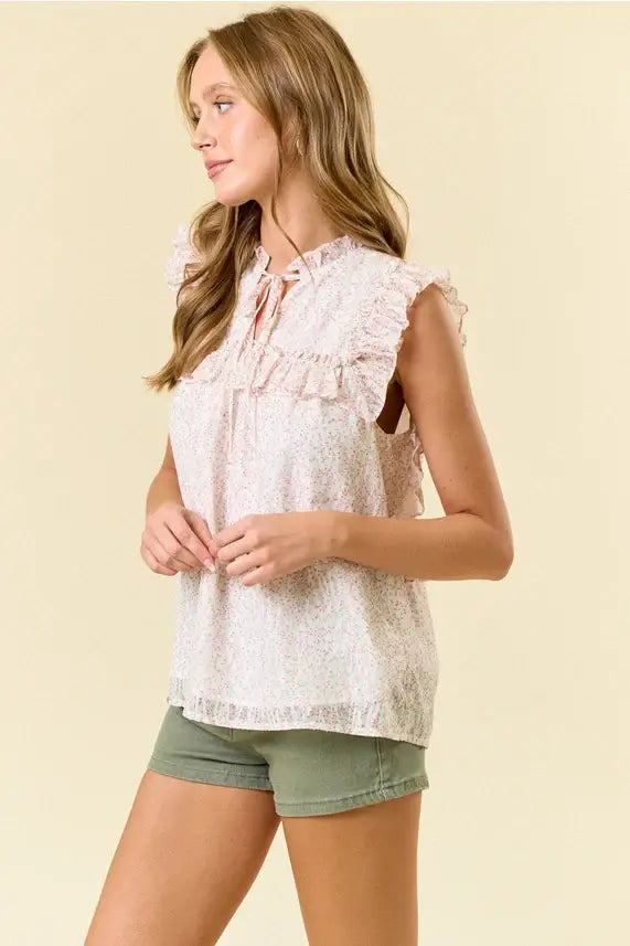 A light pink lace ditsy floral split v neck flowy blouse with ruffled sleeves and a tie-front neckline