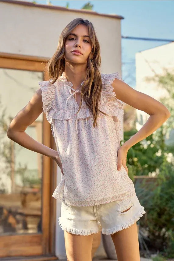 Delicate light pink ditsy floral split v neck flowy blouse with ruffled neckline and hem sleeveless top