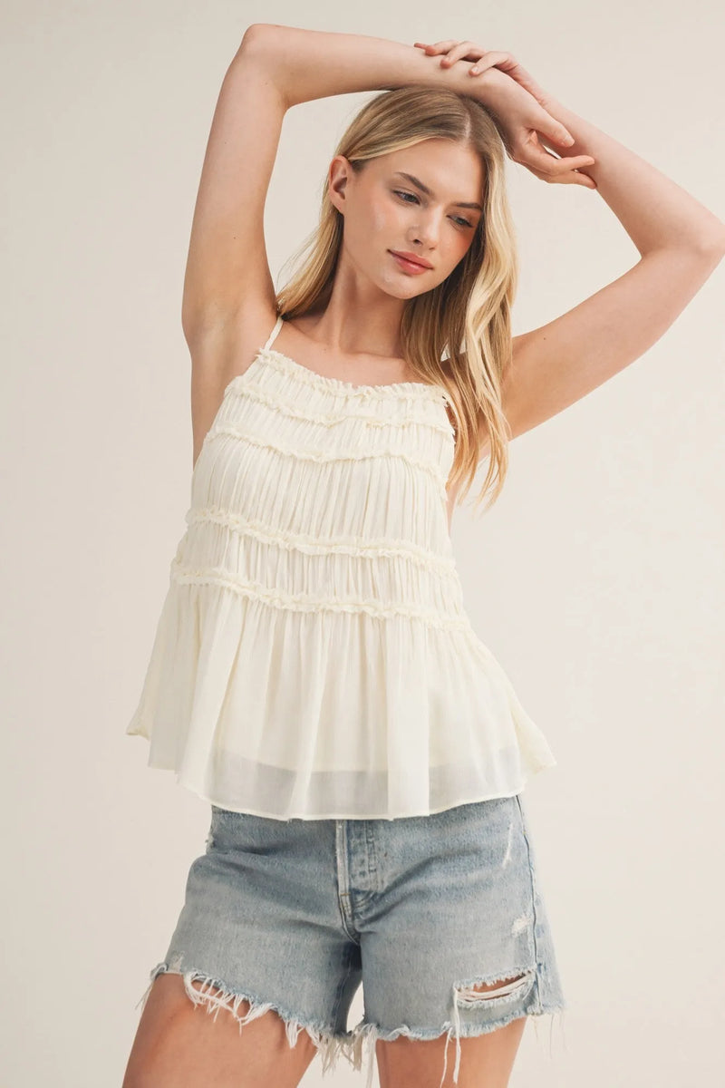 Delicate off-white tiered ruffle bodice babydoll cami with ruffled layers and thin spaghetti straps
