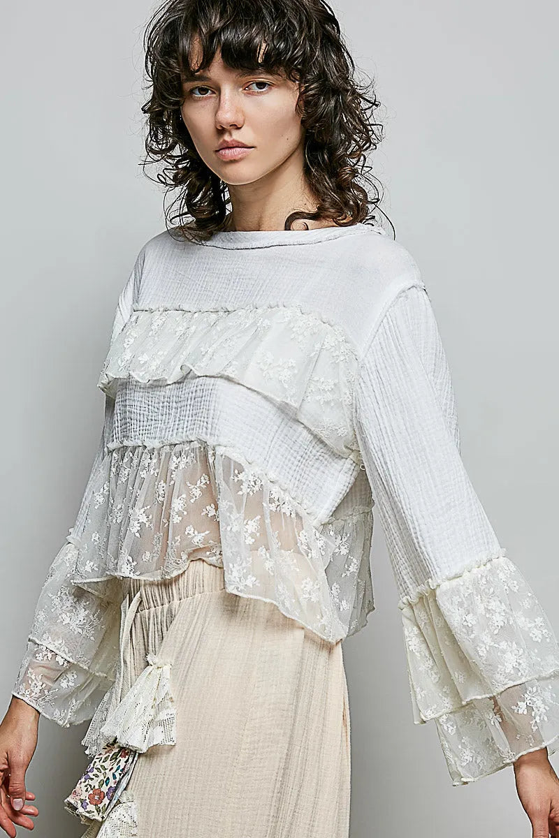 A delicate white lace ruffle blouse with round neck flared sleeve and double gauze fabric detailing