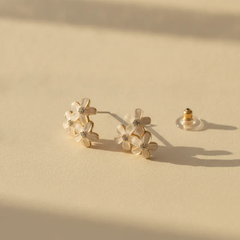 Dainty blue floral enamel flower stud earrings with gold-toned settings and clear gemstone centers