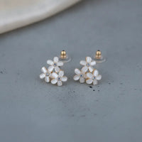 Dainty blue floral blossom stud earrings with delicate white enamel petals gold-tone settings and clear crystal centers