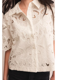 A delicate white lace midnight embroidered short sleeve top featuring intricate floral patterns and a classic collar