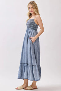 Denim blue tencel smocked tiered midi dress with a smocked bodice and ruffled hem for elegant wear