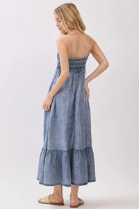 Denim blue tencel smocked tiered midi dress with delicate embroidery and frayed hem details in a tiered midi dress style