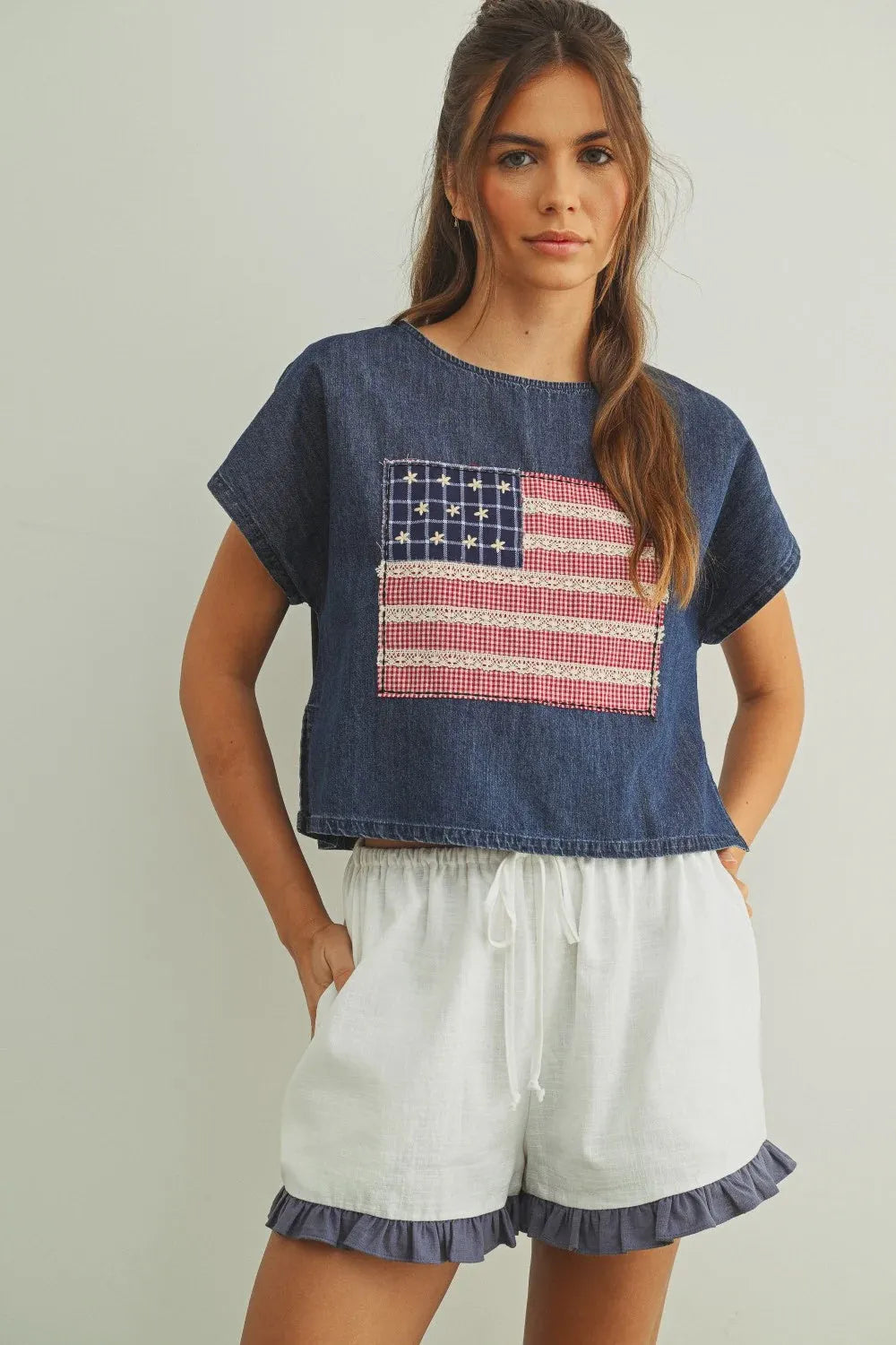 Denim crop top with mixed fabric flag patchwork in red white and blue featuring a flag patched dolman sleeve design
