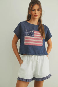 Denim crop top with mixed fabric flag patchwork in red white and blue featuring a flag patched dolman sleeve design