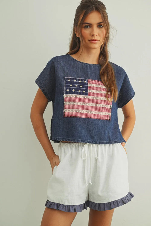 Denim crop top with mixed fabric flag patchwork in red white and blue featuring a flag patched dolman sleeve design