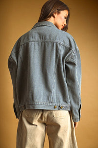 Striped pattern denim jacket in faded blue and white with vertical pinstripes and classic button closures at the waist
