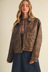 A distressed brown coated knit boxy utility jacket with tan stitching and two front flap pockets