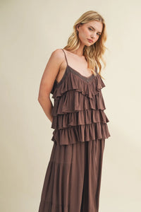 A flowing earthy brown cascading ruffle tiered maxi dress with delicate spaghetti straps and ruffled layers