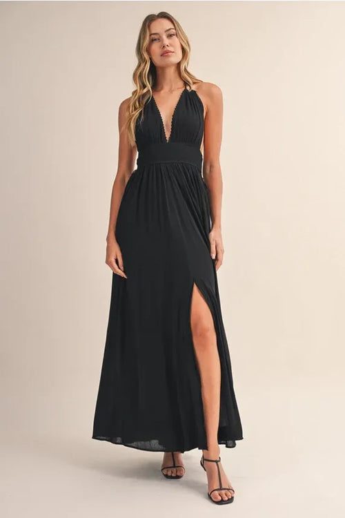 Elegant black crinkle linen maxi dress with halter neck, deep v-back, and high slit showing back side view
