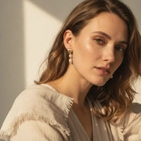 Elegant gold seashell double pearl drop earrings featuring a delicate chain and two lustrous pearls