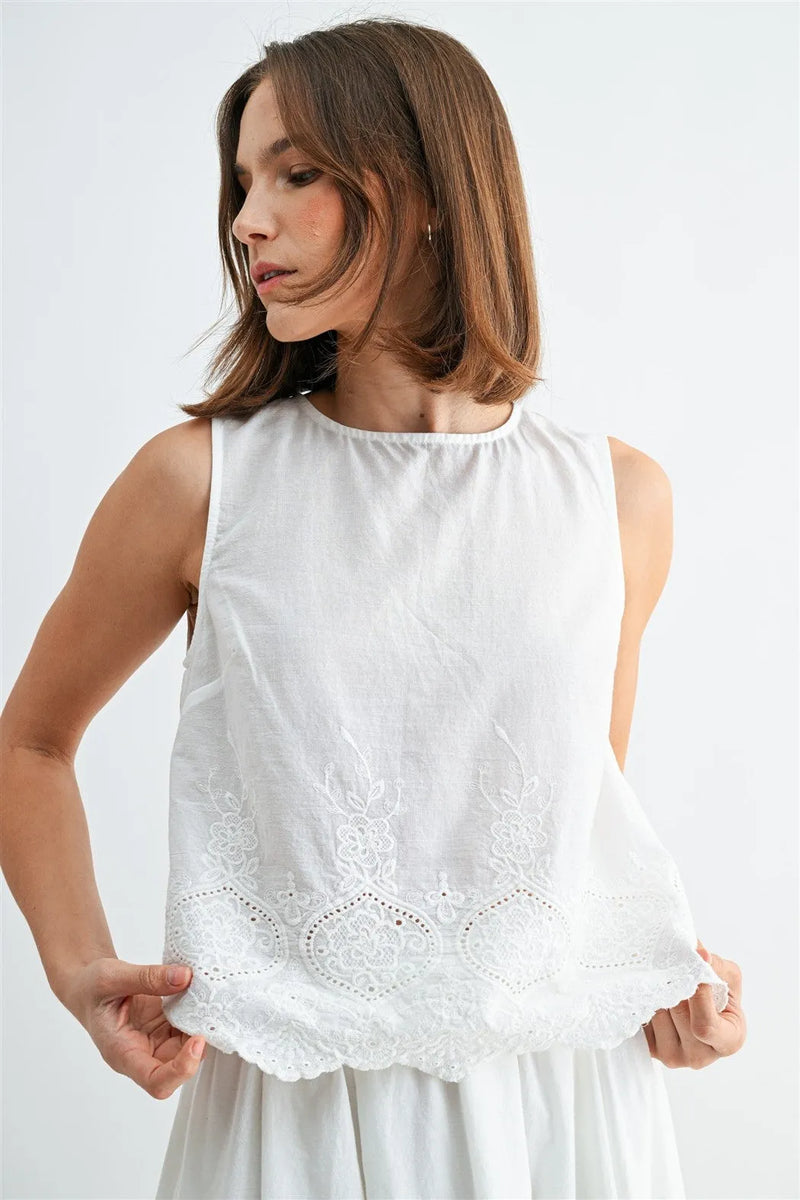 White sleeveless button blouse with delicate eyelet hem lace embroidery along the back blouse features