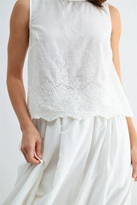 White sleeveless button blouse with delicate lace embroidery and eyelet hem featuring scalloped edges