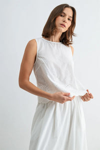 White sleeveless button blouse featuring delicate lace eyelet hem and neckline detailing with back button closure
