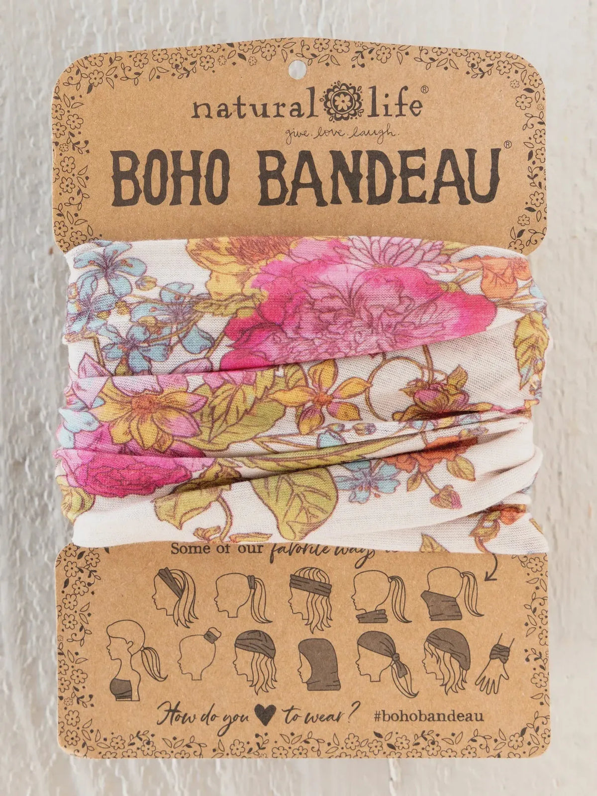 A floral-patterned boho bandeau headband in english garden cream featuring pink and yellow blossoms on stretchy fabric