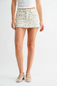 Classic mini denim high rise skort in soft cream with blue floral pattern featuring front pockets and button closure