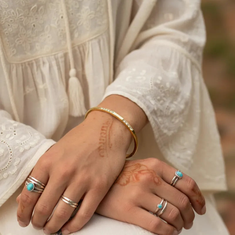 Gold crystal bangle with small embedded stones inspired by women’s boho chic clothing shop daisy collection