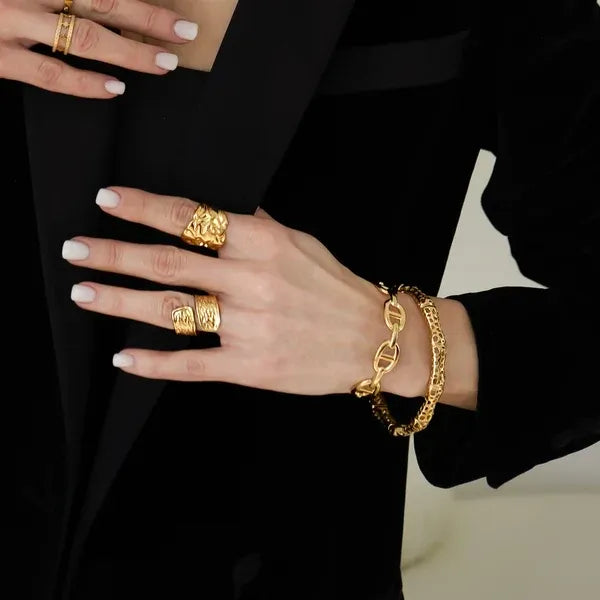 Gold chain-link bracelet featuring a textured sculptural lattice design bangle with intricate interlocking links