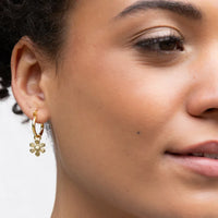 Gold-colored interchangeable charm earring with a hoop design and a dangling flower charm featuring a central pearl