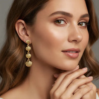 Elegant three-tier gold seashell drop statement earrings with intricate textured design perfect for formal occasions