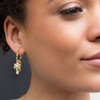 Gold hoop interchangeable charm earring with a dangling flower charm featuring a pearl and light blue stone