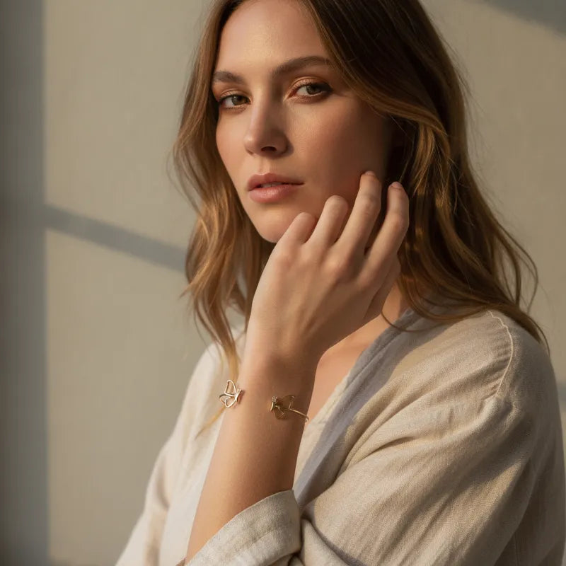 Gold plated adjustable butterfly cuff bracelet featuring a gold butterfly and flower design with adjustable fit