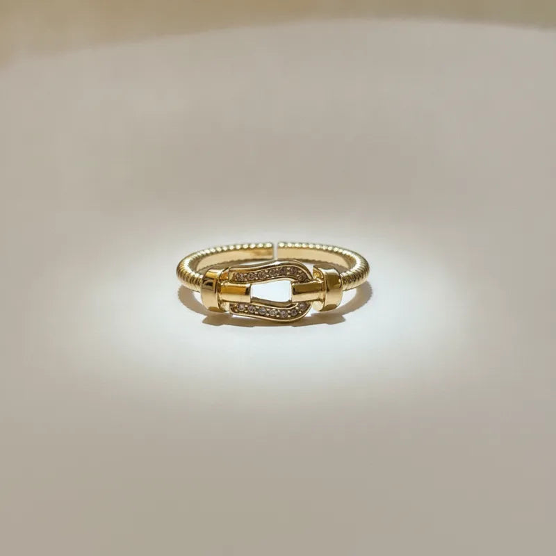 Gold plated cable band statement ring with a textured twisted band and crystal-adorned buckle design