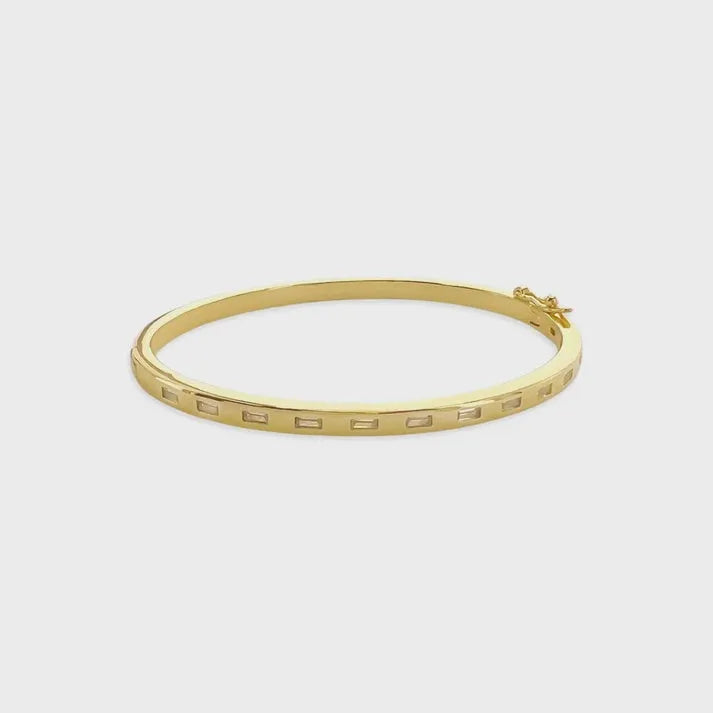 Gold-toned cubic zirconia bangle bracelet with minimalist rectangular cutouts and a small clasp mechanism