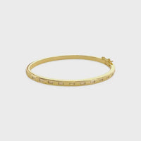 Gold-toned cubic zirconia bangle bracelet with minimalist rectangular cutouts and a small clasp mechanism