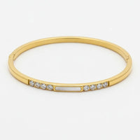 Gold-toned crystal bangle with clear crystals and central mother of pearl accent for women’s boho chic clothing shop daisy