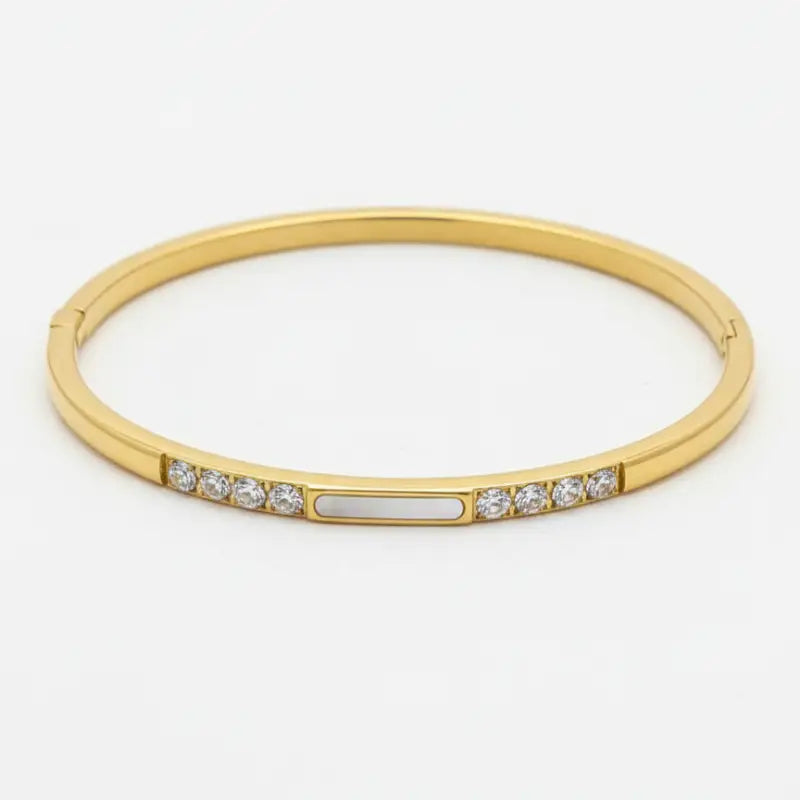Gold-toned crystal bangle with clear crystals and central mother of pearl accent for women’s boho chic clothing shop daisy