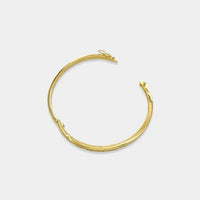 Gold-toned cubic zirconia bangle with a textured twisted design and hinged closure for elegant wear