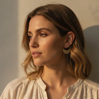 Gold-tone botanical cutout hoop earrings featuring intricate lace-like patterns for chic statement jewelry